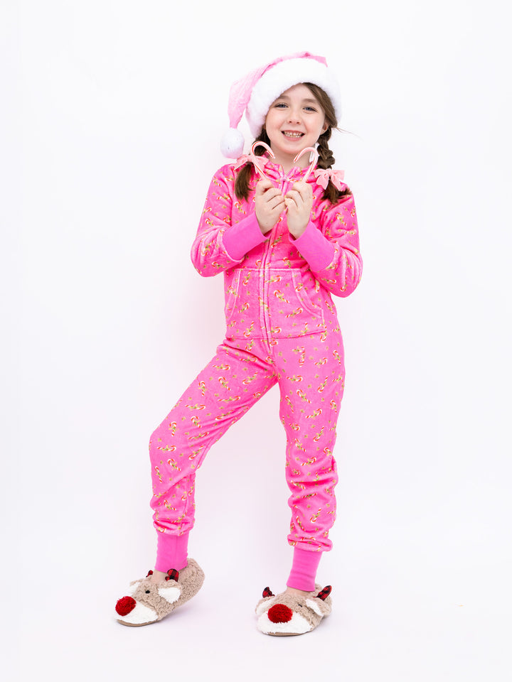 Child wearing a pink onesie with candy cane print on a white background