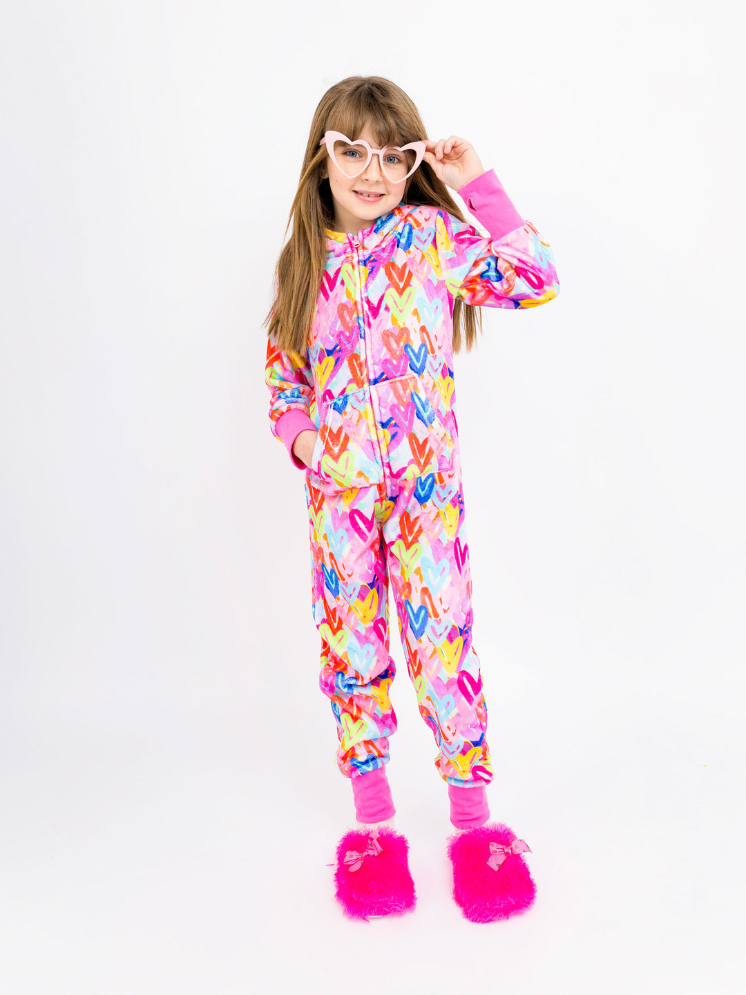 Child wearing a colorful onesie with heart patterns on a white background