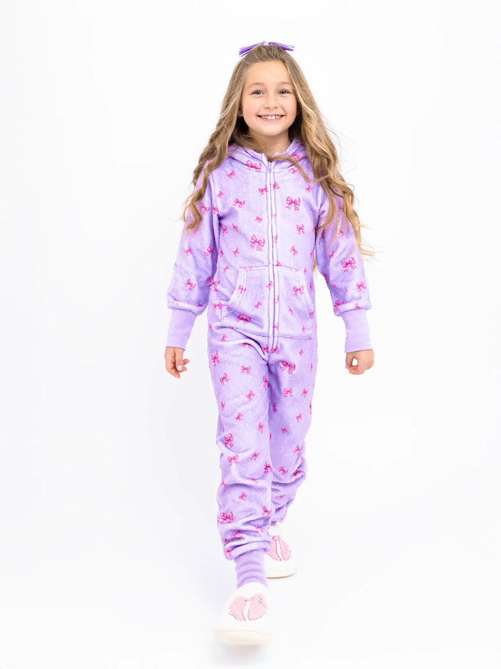 girl in lavender onesie with holiday bows pattern