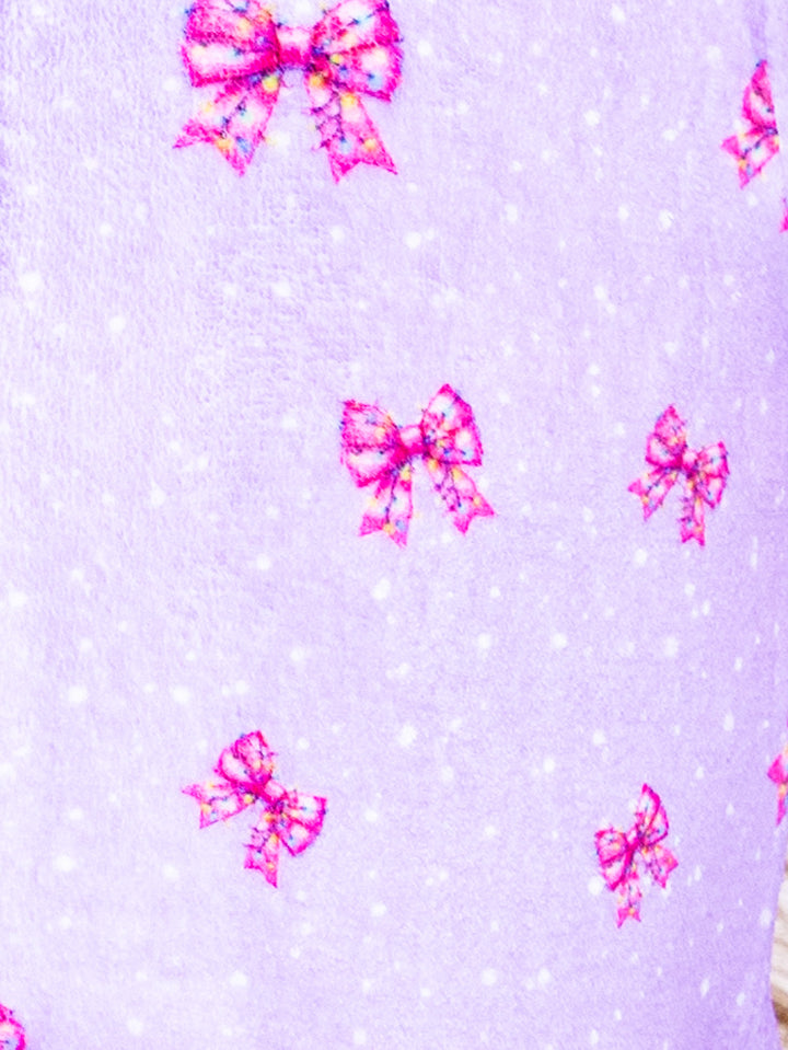 Pattern of pink bows on a light purple background with small white dots.