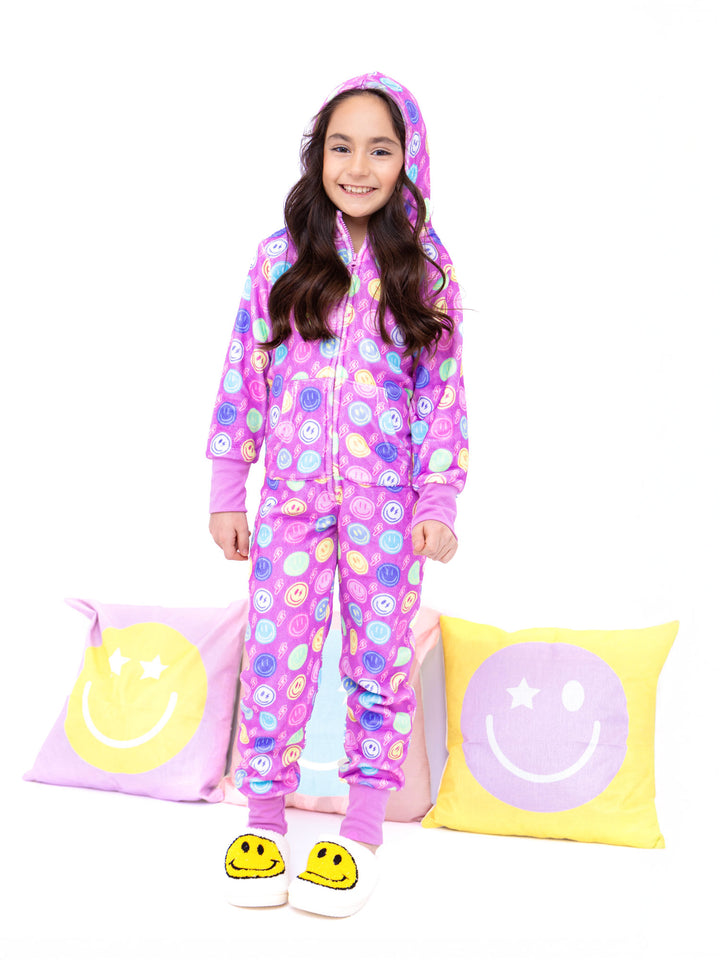 Child wearing a printed plush onesie with smiley face patterns