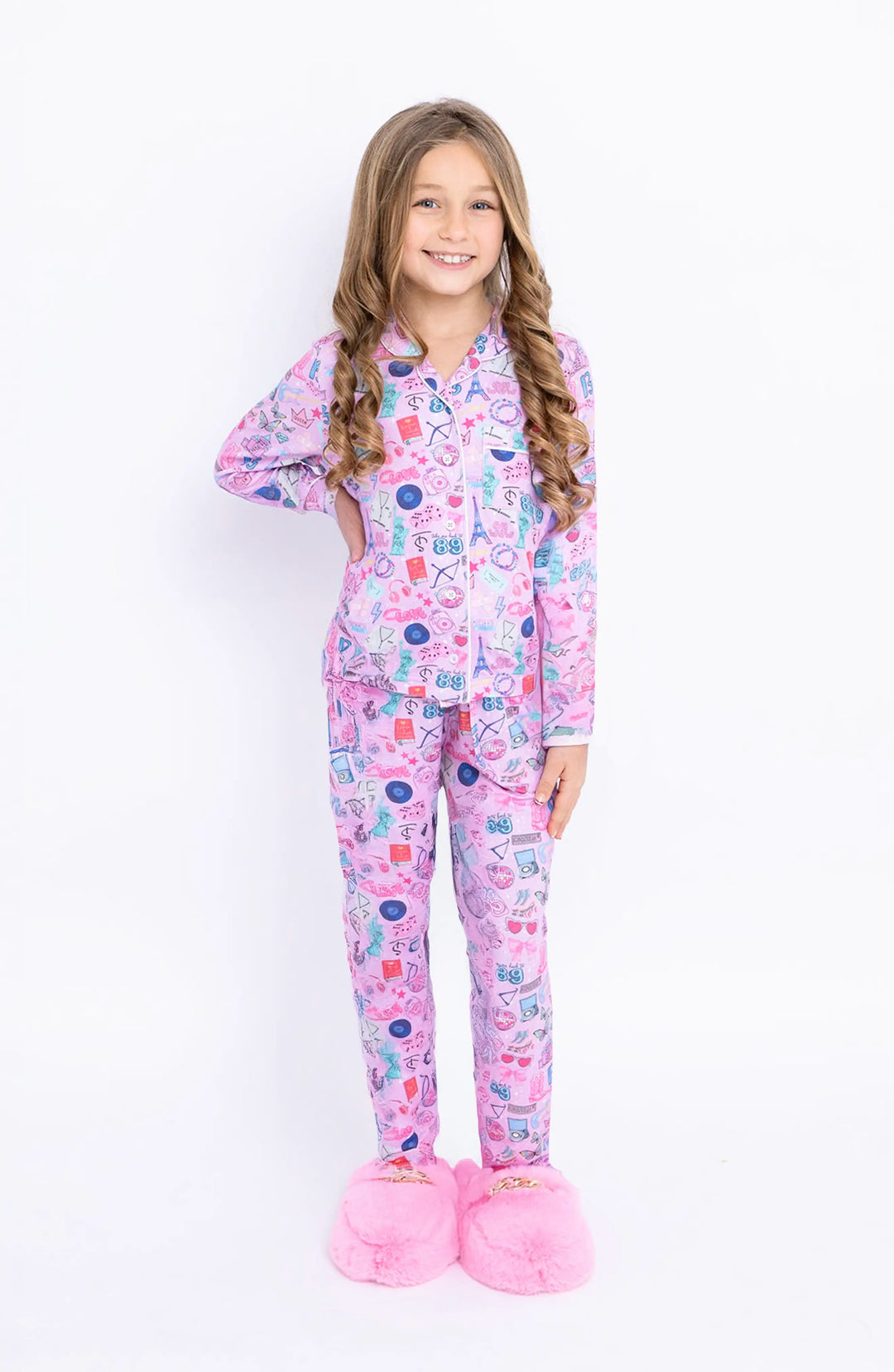 Young girl wearing a pink swifties pajama set on a white background
