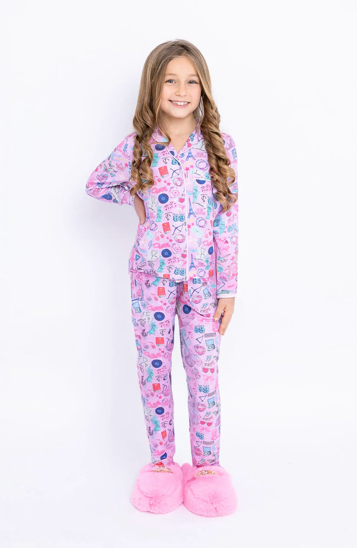 Young girl wearing a pink swifties pajama set on a white background
