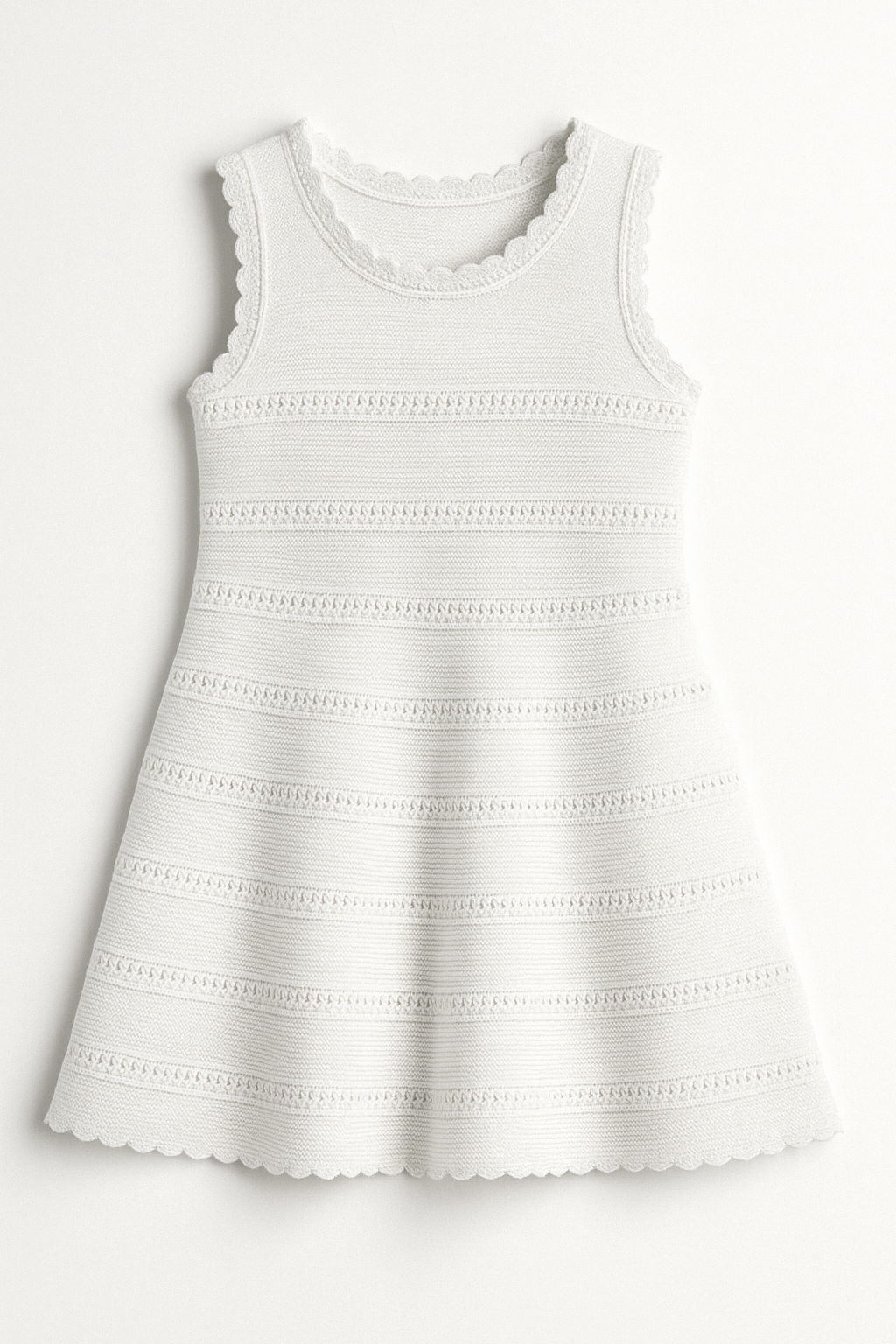 White sleeveless crochet knit dress with scallop details on a white background
