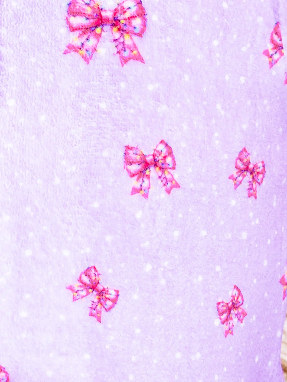 Pattern of pink bows on a light purple background