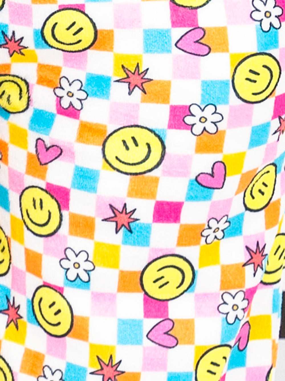 Colorful fabric with smiley faces, hearts, and flowers on a checkered background